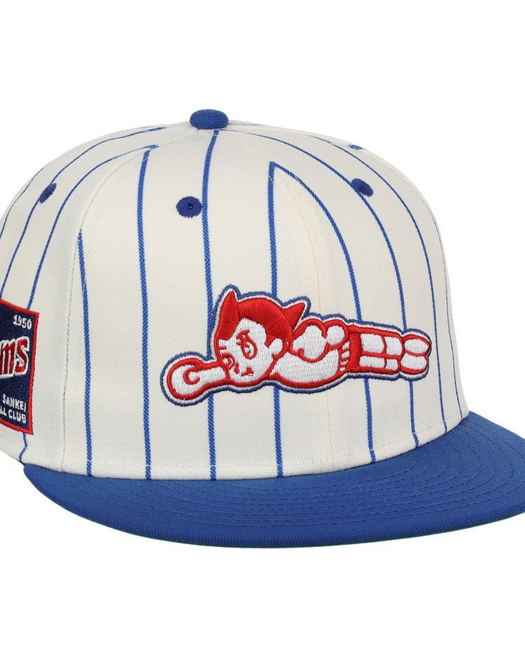 The EFF Sankei Atoms EFF Pinstripe Fitted Ballcap is a white cap with blue pinstripes, a blue brim, side patch, and red and white Atom Boy logo in a flying pose embroidered on the front.