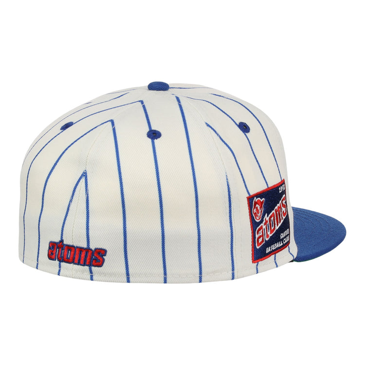 The Sankei Atoms EFF Pinstripe Fitted Ballcap by EFF is a white cap with blue pinstripes, blue brim and button, featuring an atoms logo on the back and a side patch with text and a baseball graphic. Part of the NLB Pinstripe Collection.