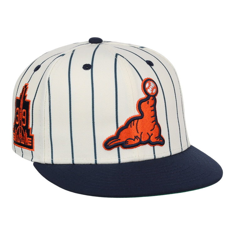 The EFF San Francisco Seals Pinstripe Fitted Ballcap features a white body with navy pinstripes, a navy brim, an orange embroidered seal with a black baseball on its nose, and an orange/navy Seals patch on the side.