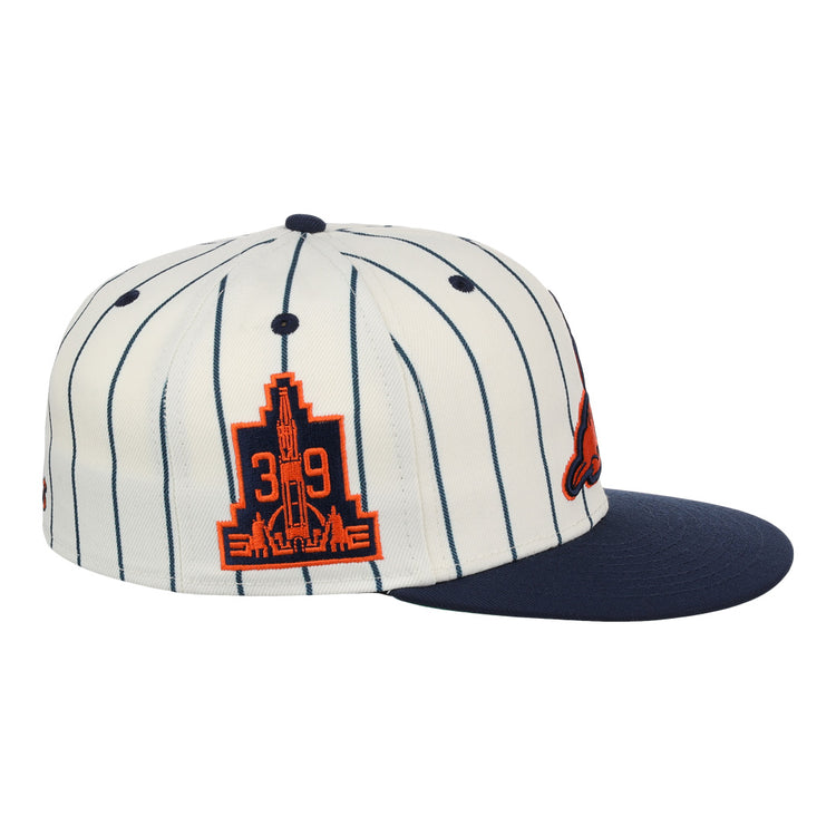The EFF San Francisco Seals Pinstripe Fitted Ballcap features white fabric with thin navy pinstripes, a navy brim, and an orange patch showing 39 and a city skyline—honoring the Seals legacy.