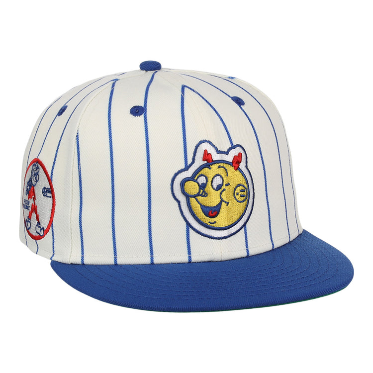 The EFF Reddy Kilowatt EFF Pinstripe Fitted Ballcap features a white base with blue pinstripes, a blue brim, and playful patches, including a smiling yellow Reddy Kilowatt face with red horns and a circular patch on the side.
