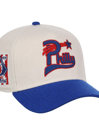 The Ebbets Field Flannels Cultural Excellence x Philadelphia Stars Snapback A-Frame features a cream crown, blue brim, red and blue Philly star logo, and Baseball Centennial 1839–1939 patch—a stylish tribute to Negro League Baseball.