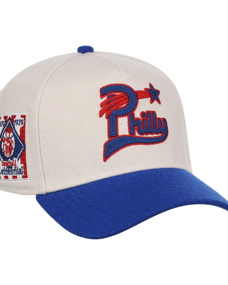 The Ebbets Field Flannels Cultural Excellence x Philadelphia Stars Snapback A-Frame features a cream crown, blue brim, red and blue Philly star logo, and Baseball Centennial 1839–1939 patch—a stylish tribute to Negro League Baseball.