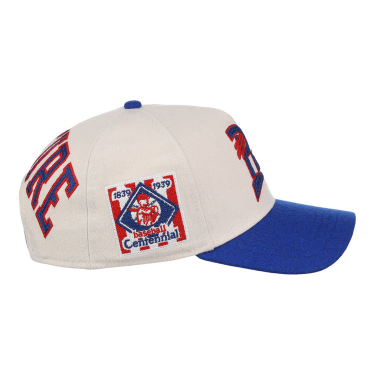 Side view of the Cultural Excellence x Philadelphia Stars Snapback A-Frame by Ebbets Field Flannels, a beige cap with blue brim and 1839-1939 Centennial patch—ideal for streetwear enthusiasts and Negro League Baseball history fans.