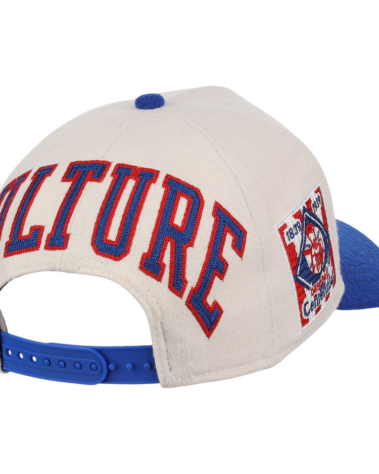 The Ebbets Field Flannels Cultural Excellence x Philadelphia Stars Snapback A-Frame features a beige crown, blue brim and snapback, “CULTURE” in bold red and blue on the back, and a side logo patch inspired by Negro League Baseball streetwear.