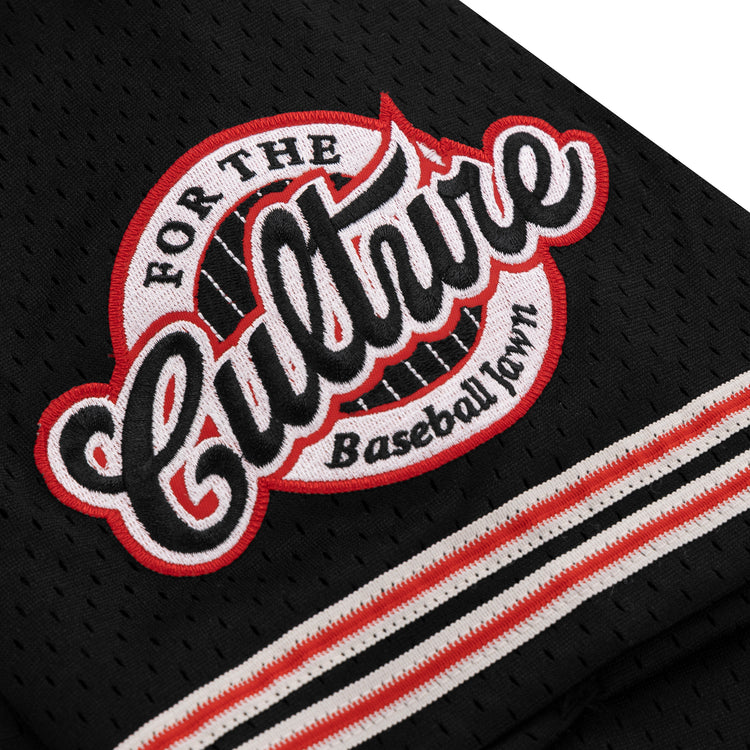 A close-up of the EFF Cultural Excellence x Philadelphia Stars Button Down Jersey shows black mesh fabric with a patch reading “For The Culture Baseball Town,” in bold white and red letters, inspired by Negro League Baseball, with striped black, white, and red trim.