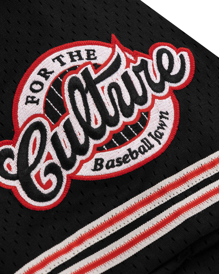 A close-up of the EFF Cultural Excellence x Philadelphia Stars Button Down Jersey shows black mesh fabric with a patch reading “For The Culture Baseball Town,” in bold white and red letters, inspired by Negro League Baseball, with striped black, white, and red trim.