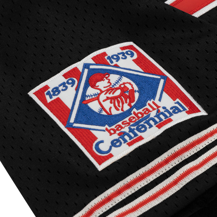 A close-up of the EFF Cultural Excellence x Philadelphia Stars Button Down Jersey, a black sports jersey inspired by Negro League Baseball, featuring a red, white, and blue 1839–1939 Baseball Centennial patch with a batter in a pentagon.