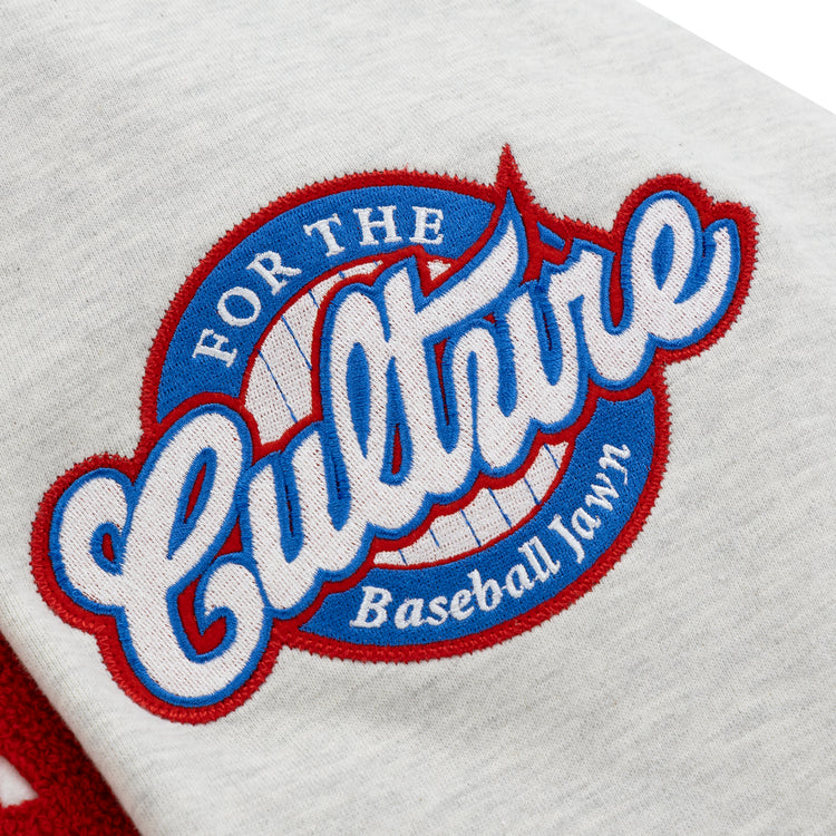 A white fabric patch on the EFF Cultural Excellence x Philadelphia Stars French Terry Hooded Sweatshirt features For the Culture in blue script over a red-bordered baseball, with Baseball Lawn below in bold red and blue stitching.