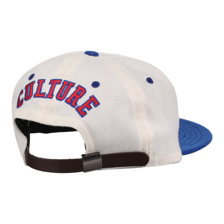 The EFF Cultural Excellence x Philadelphia Stars Wool Ballcap is a white cap with a blue brim, blue stitched eyelets, “CULTURE” embroidered in red and blue on the back, and an adjustable brown strap with metal clasp. Inspired by Negro League Baseball.