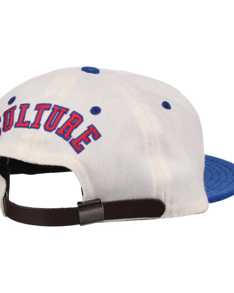 The EFF Cultural Excellence x Philadelphia Stars Wool Ballcap is a white cap with a blue brim, blue stitched eyelets, “CULTURE” embroidered in red and blue on the back, and an adjustable brown strap with metal clasp. Inspired by Negro League Baseball.