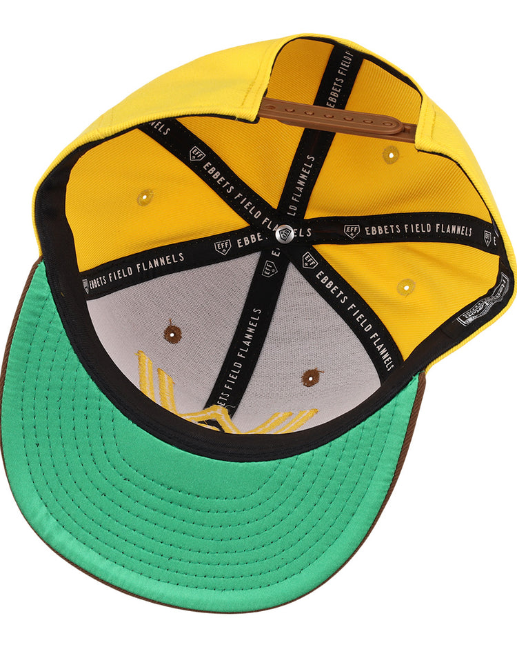 A top-down view of the Walla Walla Padres Ebbets Field Flannels MiLB Vintage Snapback shows a yellow crown, green underbrim, brown edge, black interior bands labeled with the brand, and visible sweatband and structure.