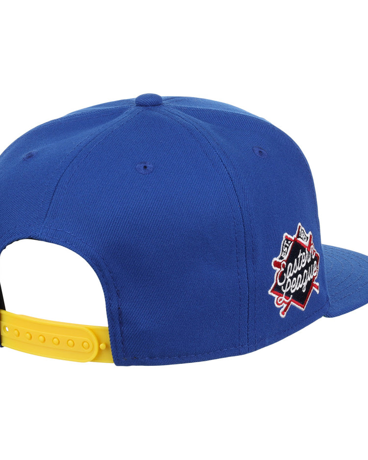 The Vermont Mariners EFF MiLB Vintage Snapback by Ebbets Field Flannels is a blue cap with a yellow adjustable strap and Classic League patch with crossed bats, inspired by the Vermont Mariners. Shown from back and side.