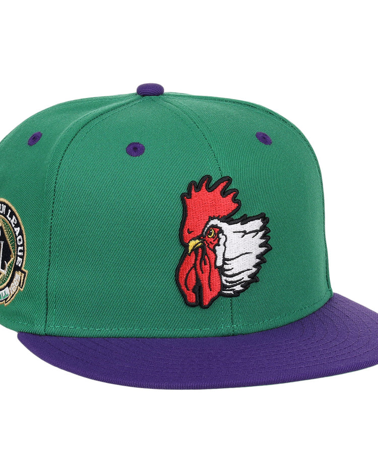 The Port City Roosters EFF MiLB Vintage Snapback by Ebbets Field Flannels is a green cap with a purple brim, featuring an embroidered rooster head and a Southern League patch, inspired by vintage minor league style.