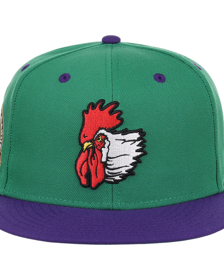 The Port City Roosters EFF MiLB Vintage Snapback by Ebbets Field Flannels features a green cap, purple brim, and an embroidered red and white rooster head—ideal for fans of vintage Minor League or Port City Roosters memorabilia.