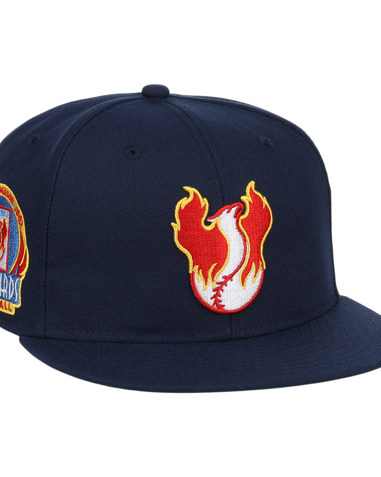 The Phoenix Firebirds EFF MiLB Vintage Snapback by Ebbets Field Flannels is a navy snapback with a flaming baseball logo up front and a colorful embroidered Phoenix Firebirds patch on the side, inspired by vintage Pacific Coast League style.