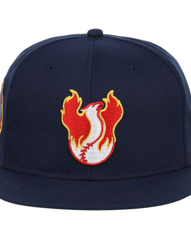 The Phoenix Firebirds EFF MiLB Vintage Snapback by Ebbets Field Flannels features a navy blue design with a white baseball, red stitching, and orange-yellow flames embroidered on the front.