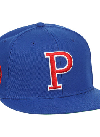 The Ebbets Field Flannels Peoria Chiefs EFF MiLB Vintage Snapback features a blue design with a large red and white P on the front, side patch with text and logo, plus an adjustable snapback closure for the perfect fit.