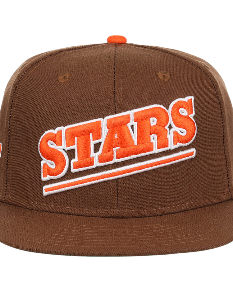 The Las Vegas Stars EFF MiLB Vintage Snapback by Ebbets Field Flannels is a brown cap with STARS boldly embroidered in orange and white diagonally, featuring an orange top button and snapback closure.