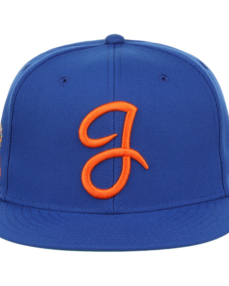 The Ebbets Field Flannels Jacksonville Suns EFF MiLB Vintage Snapback is a blue cap with an orange embroidered J logo, flat brim, snapback closure, and visible stitching—offering classic style and adjustable comfort.