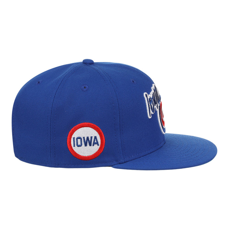 The Iowa Cubs EFF MiLB Vintage Snapback by Ebbets Field Flannels features a blue adjustable design, a circular side patch with IOWA in red and blue letters, white cursive embroidery on the front, and classic minor league style.