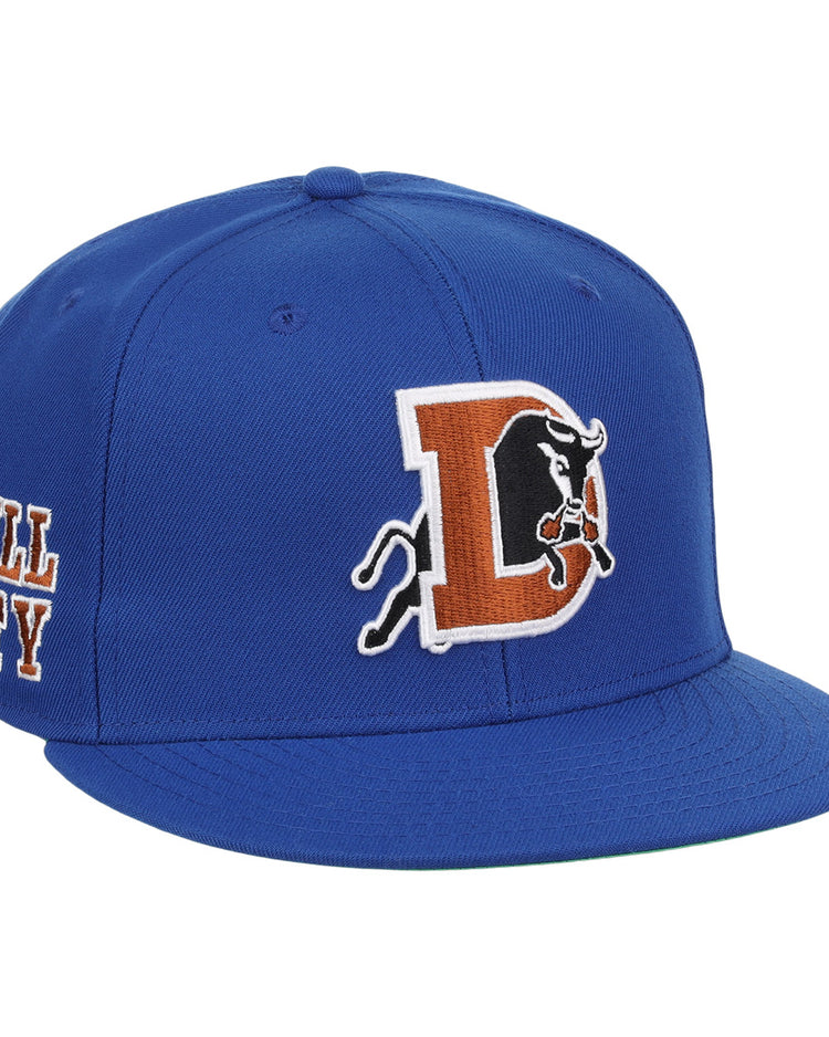 The Durham Bulls EFF MiLB Vintage Snapback by Ebbets Field Flannels features a large “D” with charging bull logo and BULL CITY embroidered on the side, capturing a vintage Minor League style inspired by the Durham Bulls.