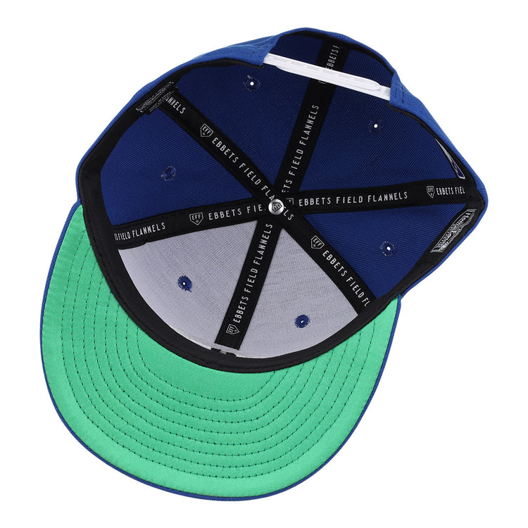 A look inside the Columbus Jets EFF MiLB Vintage Snapback from Ebbets Field Flannels shows black seams with EBBETS FIELD FLANNELS labels and a green underbrim, capturing International League pennant heritage.