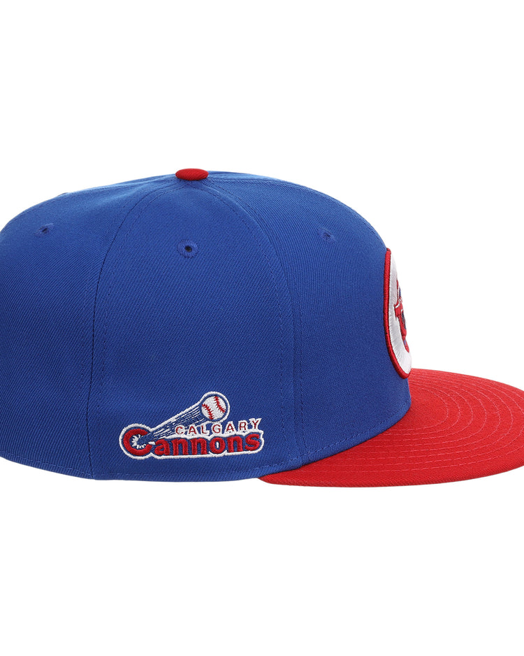 The Calgary Cannons EFF MiLB Vintage Snapback by Ebbets Field Flannels is a blue cap with a red brim, featuring the team logo, name embroidered on the side, and a baseball with bat graphic.