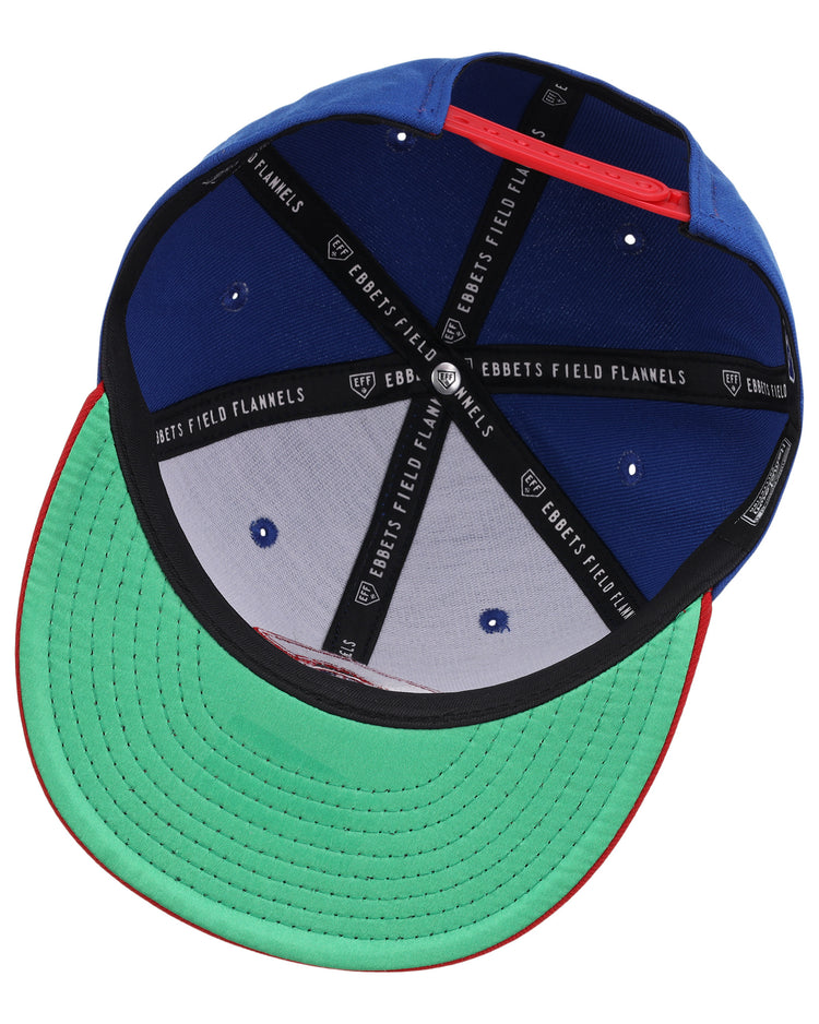 The Calgary Cannons EFF MiLB Vintage Snapback by Ebbets Field Flannels features a green underbrim, black lining with “EBBETS FIELD FLANNELS” text, blue panels, and white stitched ventilation holes—classic Pacific Coast League style.