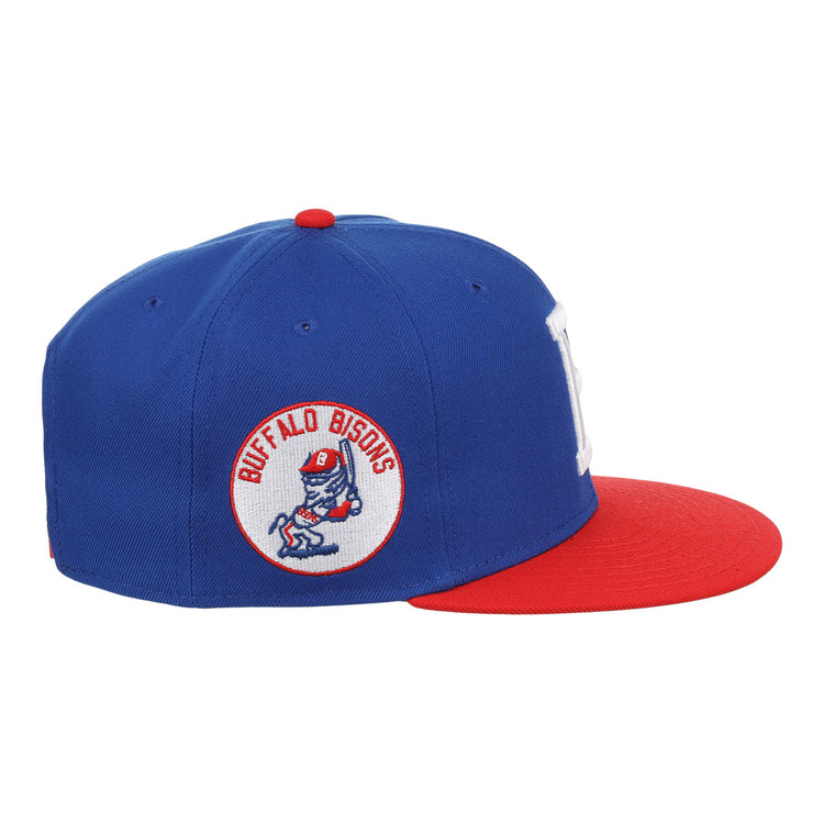 The Ebbets Field Flannels Buffalo Bisons EFF MiLB Vintage Snapback features a blue crown, red brim, and side patch of a cartoon bison swinging a bat—adding classic minor league style to any fan’s wardrobe. Adjustable snapback for a perfect fit.