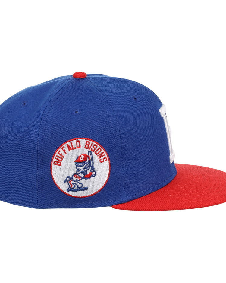 The Ebbets Field Flannels Buffalo Bisons EFF MiLB Vintage Snapback features a blue crown, red brim, and side patch of a cartoon bison swinging a bat—adding classic minor league style to any fan’s wardrobe. Adjustable snapback for a perfect fit.