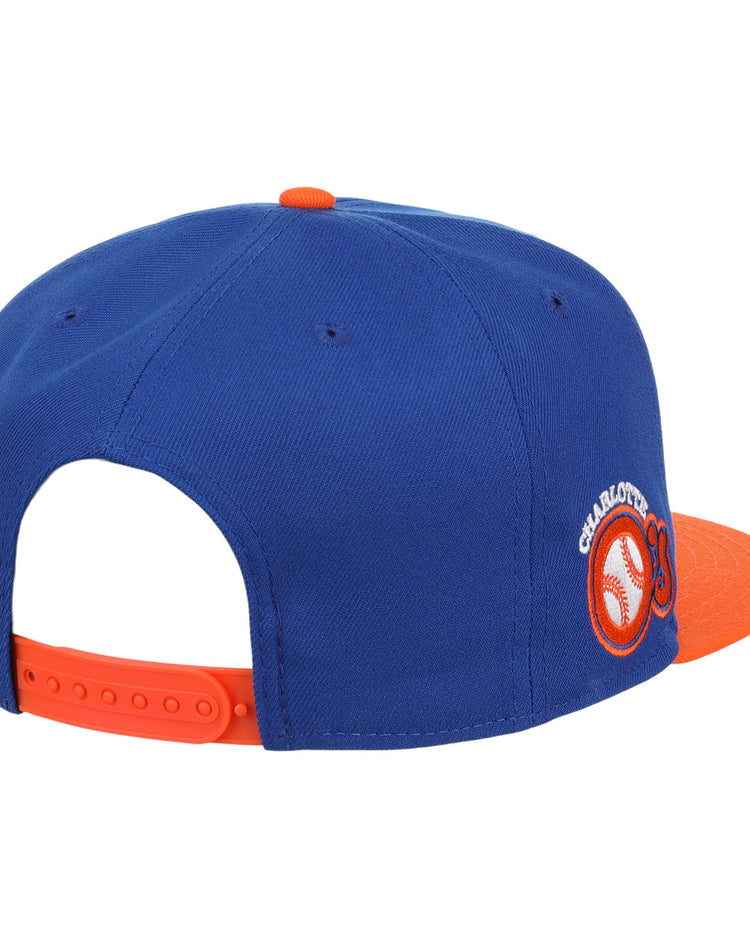 The Charlotte Orioles EFF MiLB Vintage Snapback by Ebbets Field Flannels features a blue and orange design, round CHARLOTTE embroidered patch with baseball graphic, orange brim, and adjustable strap.