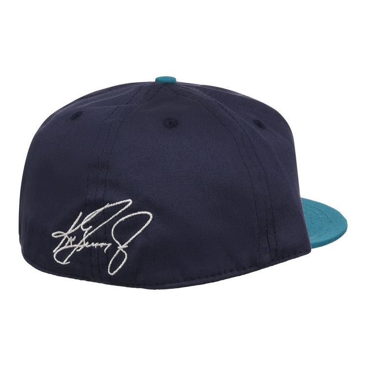 The Ebbets Field Flannels Ken Griffey Jr. 1995 Signature Series Ballcap is a navy wool cap with a teal brim, seen from the back, and features a white embroidered signature on the left side.