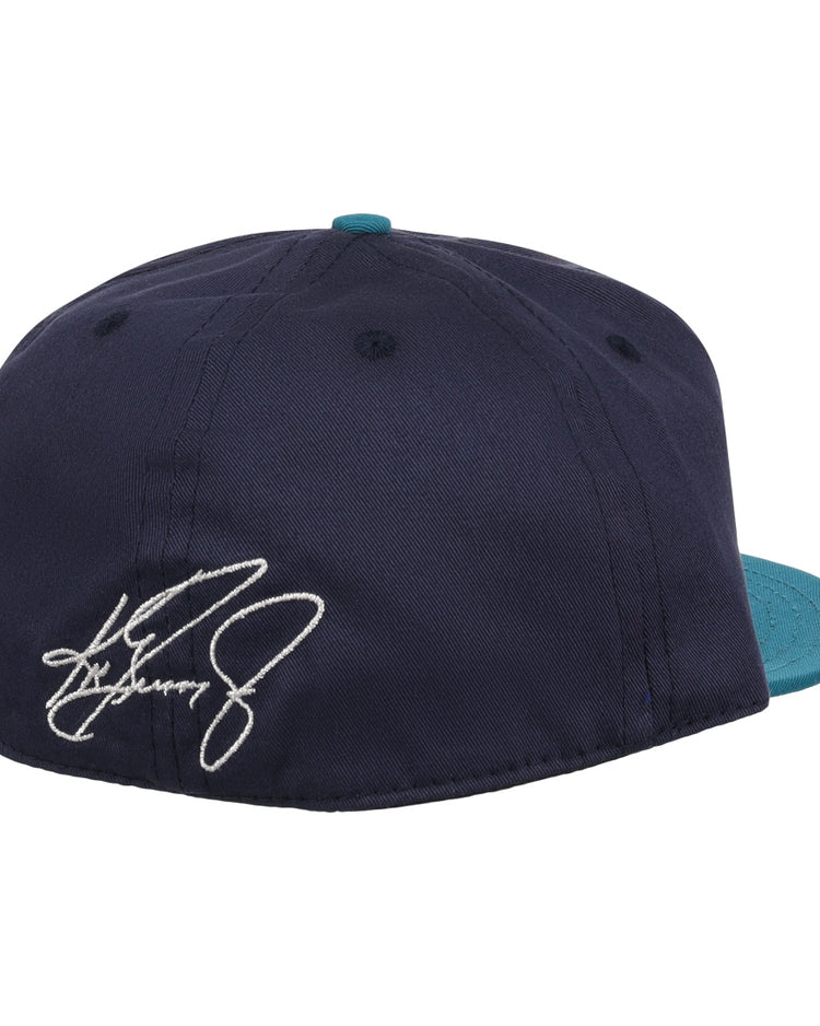 The Ebbets Field Flannels Ken Griffey Jr. 1995 Signature Series Ballcap is a navy wool cap with a teal brim, seen from the back, and features a white embroidered signature on the left side.