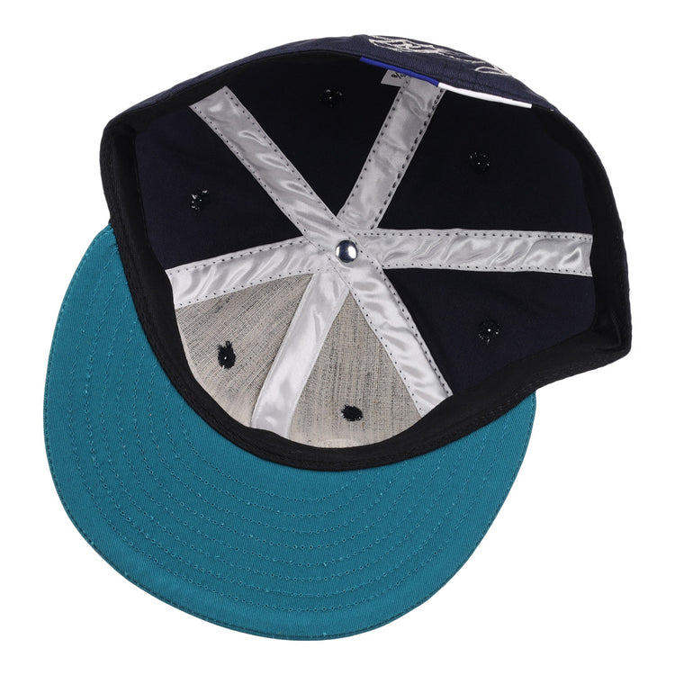 Inside the Ken Griffey Jr. 1995 Signature Series Ballcap by Ebbets Field Flannels: navy wool fabric, a shiny silver X-shaped inner band, and a teal brim with visible stitching.