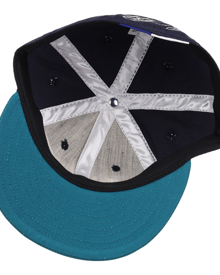 Inside the Ken Griffey Jr. 1995 Signature Series Ballcap by Ebbets Field Flannels: navy wool fabric, a shiny silver X-shaped inner band, and a teal brim with visible stitching.