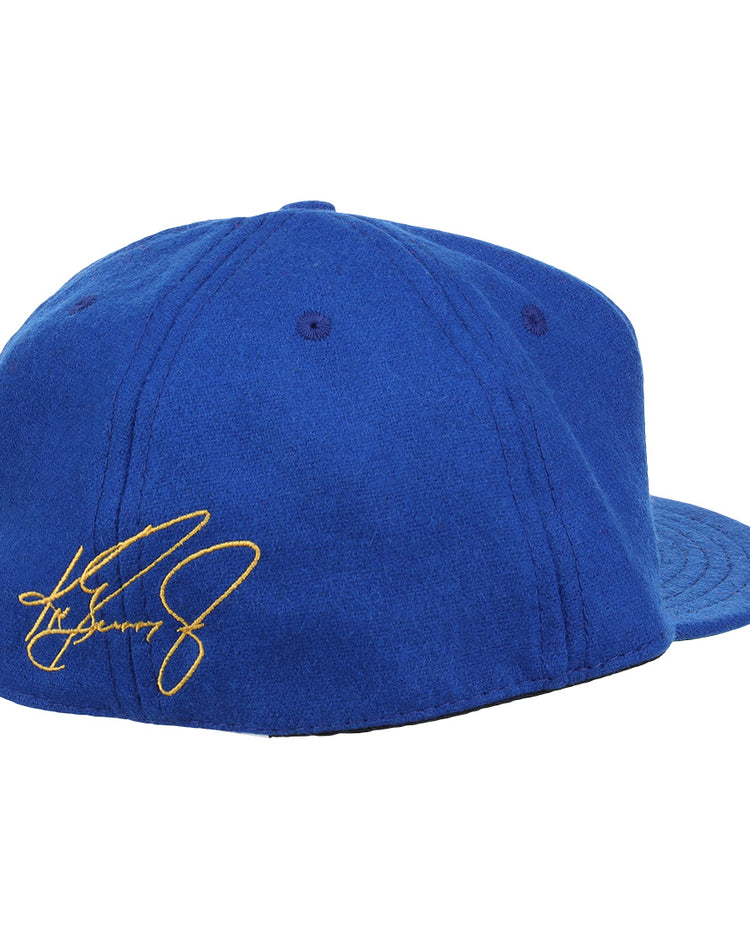 The Ebbets Field Flannels Ken Griffey Jr. 1989 Signature Series Ballcap is shown from the back in royal blue wool, with visible stitching, top eyelets, and a yellow embroidered signature on the left side.
