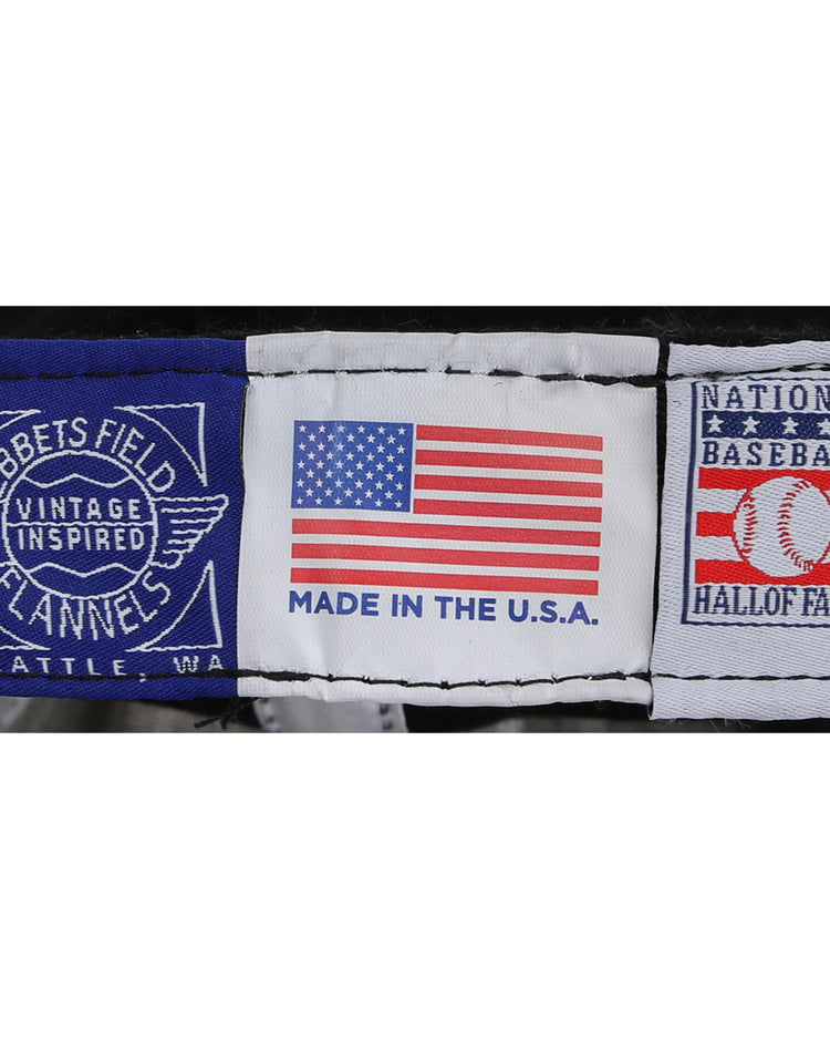 Three fabric labels: one with Ebbets Field Flannels Cal Ripken Jr. Signature Series, one featuring an American flag and Made in the U.S.A., and one with National Baseball Hall of Fame and a baseball graphic—ideal for vintage ballcap collectors.