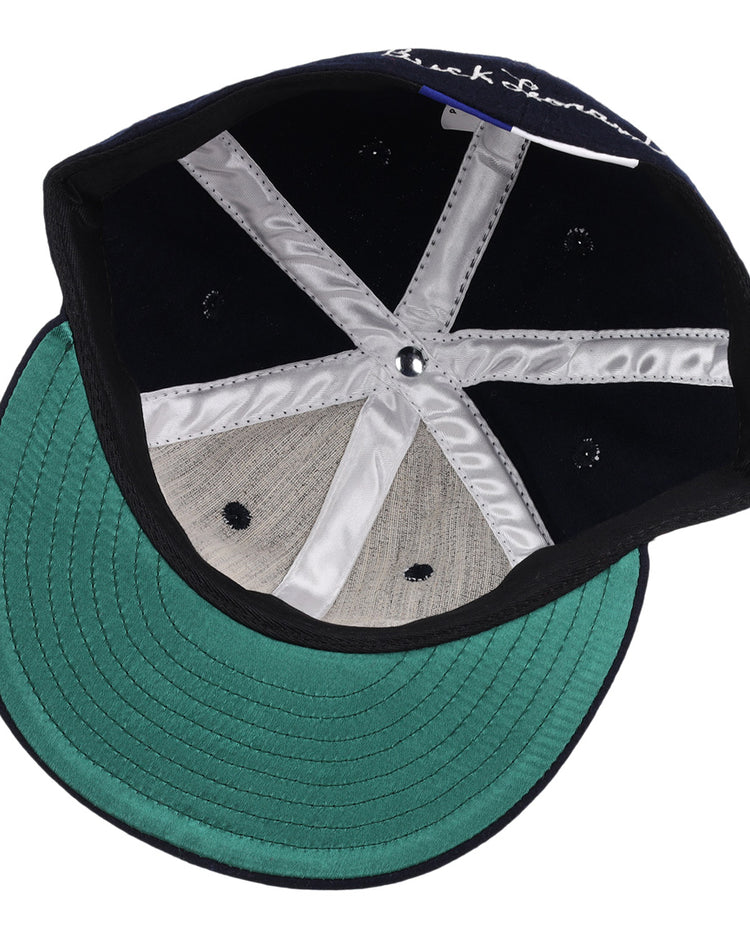 The Buck Leonard Signature Series Ballcap by Ebbets Field Flannels features a green underbrim, silver stitching, black inner panels, a size tag, and vintage details inspired by Negro Leagues legend Buck Leonard.