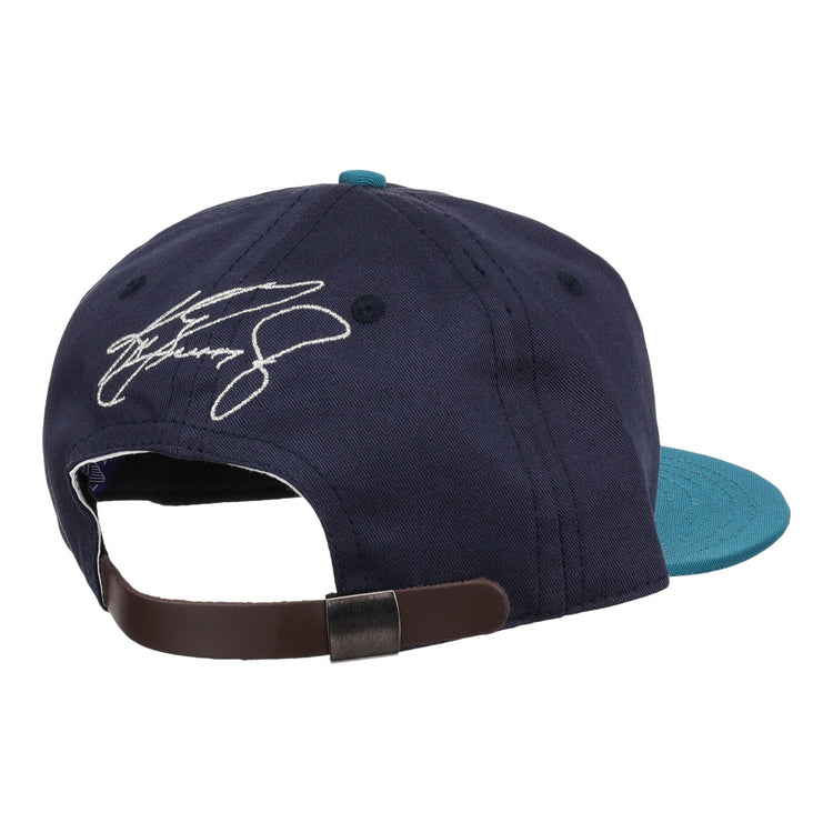 The Ken Griffey Jr. 1995 Signature Series Ballcap by Ebbets Field Flannels, shown from the back in navy blue and teal wool, features an adjustable brown strap and a white embroidered signature above the opening.