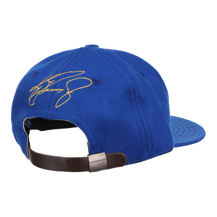 Shown from the back, the Ken Griffey Jr. 1989 Signature Series Ballcap by Ebbets Field Flannels features blue vintage wool, an adjustable brown strap with metal clasp, and a yellow signature embroidered on the top left side—ideal for collectors.