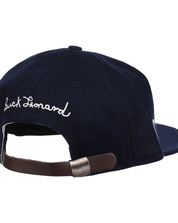 The Buck Leonard Signature Series Ballcap by Ebbets Field Flannels is a navy vintage wool cap seen from the back, with white cursive Buck Leonard embroidery and an adjustable brown strap with metal clasp honoring the Negro Leagues legend.