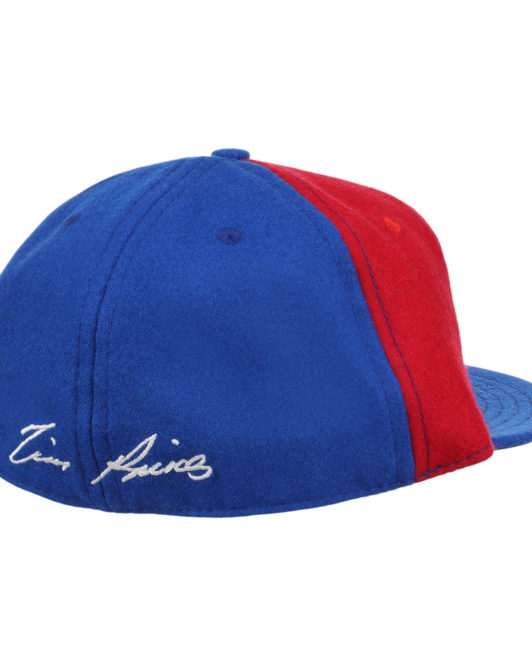 The Ebbets Field Flannels Tim Raines Signature Series Ballcap is a vintage wool cap in blue and red, with two panels of each color and a white Tim Raines signature embroidered on the blue section near the back.