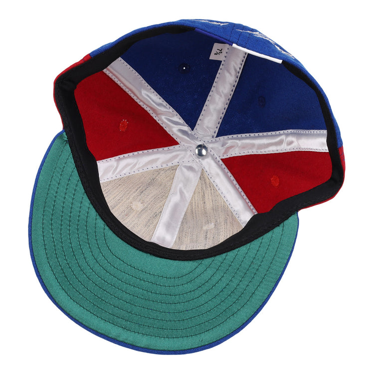 The inside of the Ebbets Field Flannels Tim Raines Signature Series Ballcap features green underbill, red and blue panels, white stitching, a silver crown button, and a visible size tag.