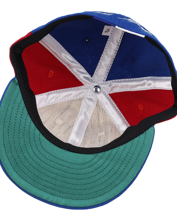 The inside of the Ebbets Field Flannels Tim Raines Signature Series Ballcap features green underbill, red and blue panels, white stitching, a silver crown button, and a visible size tag.
