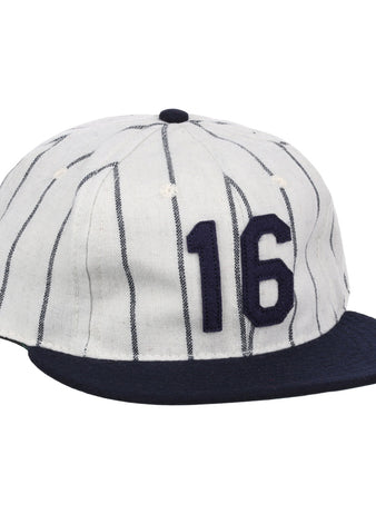 The Ebbets Field Flannels Whitey Ford Signature Series Ballcap is a vintage-style white wool cap with navy vertical pinstripes, a navy brim, and the number 16 in bold navy on the front.