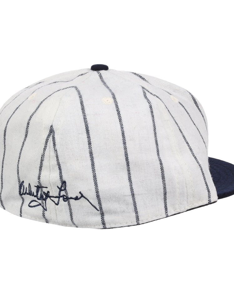 The Ebbets Field Flannels Whitey Ford Signature Series Ballcap features vintage wool, thin navy pinstripes, a solid navy brim, and a black autograph on the side inspired by Whitey Ford’s iconic cap style.