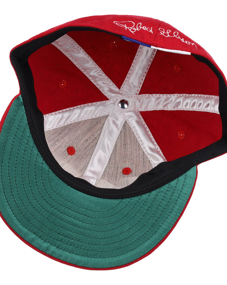 The Bob Gibson Signature Series Ballcap by Ebbets Field Flannels features vintage wool, a green brim, white inner stitching, center metallic button, and a white signature on the inner red section above the brim.