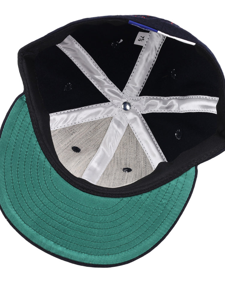 The Ozzie Smith Signature Series Ballcap by Ebbets Field Flannels features a green brim, grey panels, white interior seams, a blue center button, and a size tag—all visible on the USA-made vintage wool cap’s underside.