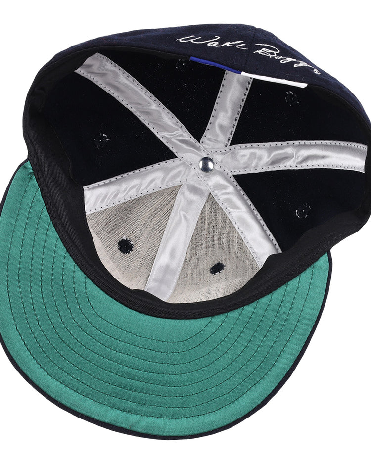 An inside view of the Wade Boggs Signature Series Ballcap by Ebbets Field Flannels features a green brim, black inner band, white stitched panels, and a central button.